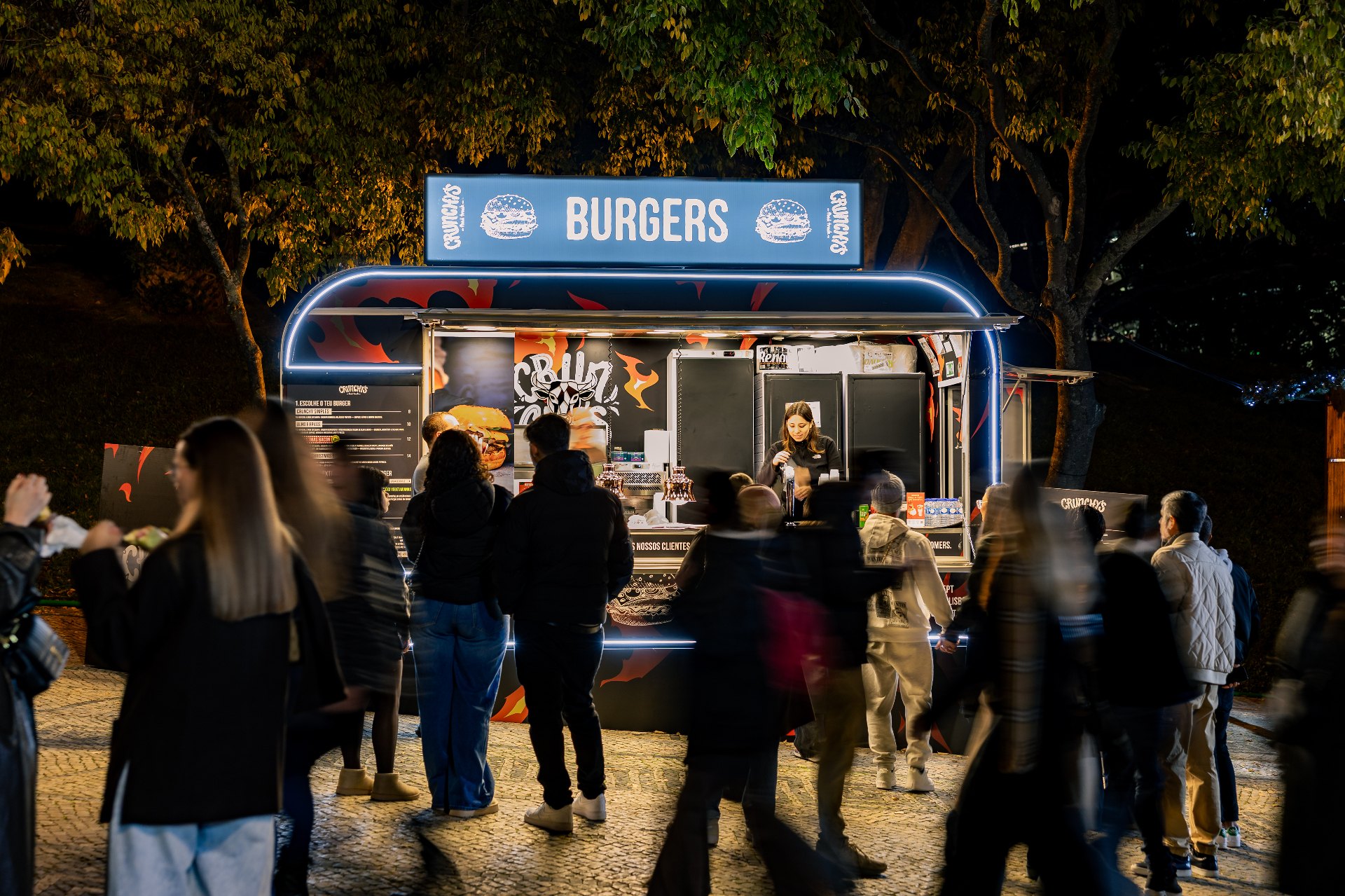 Food truck Crunchy's em ação, com fila de clientes e equipa a servir num evento à noite