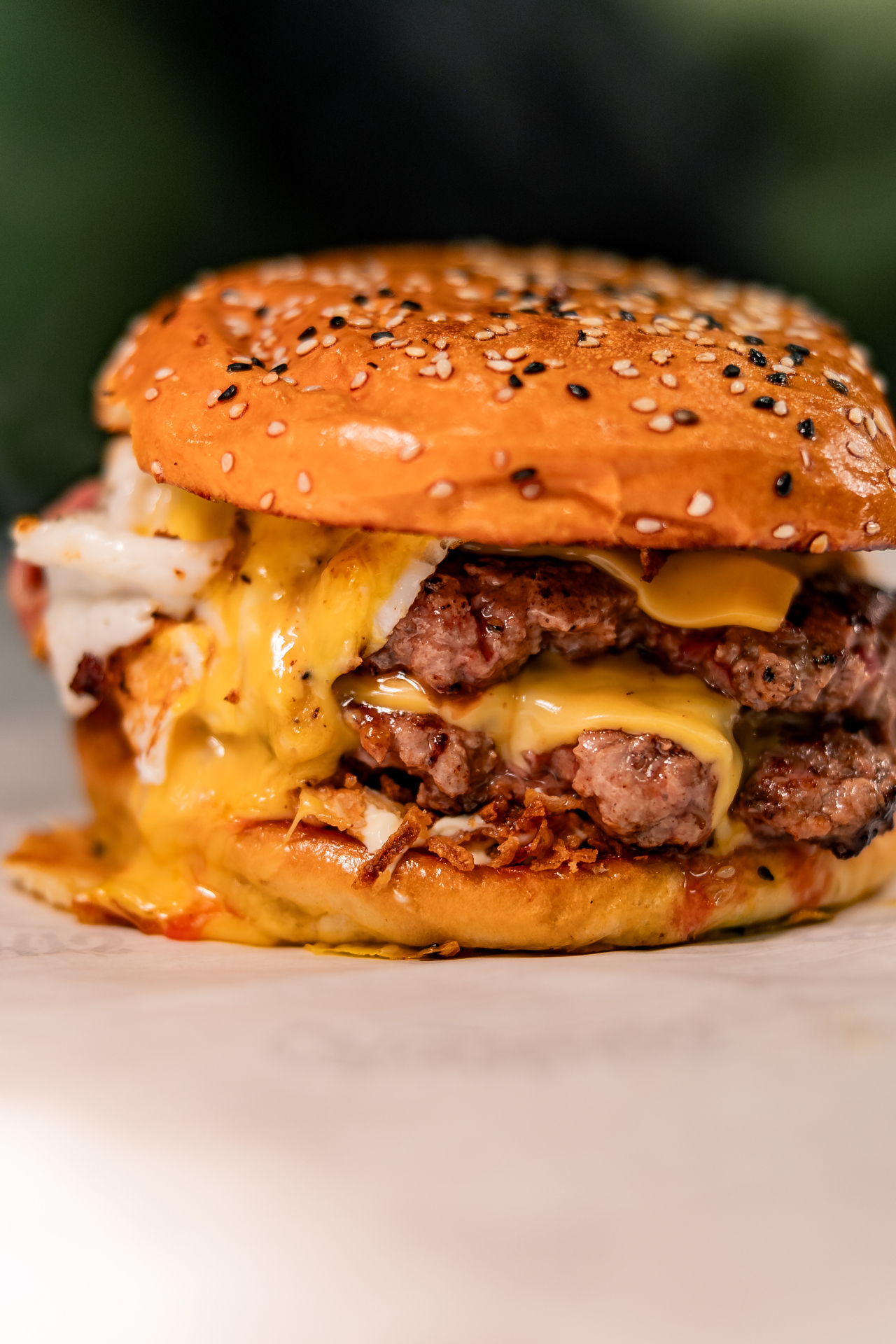 Close-up de hambúrguer Crunchy's com cheddar derretido e pão brioche